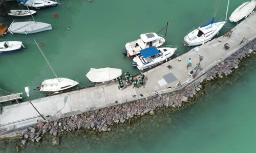 Aerial drone shot of the MONOCLE project participants in a group by the lake