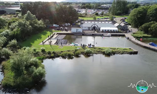 Aerial drone shot of the MONOCLE project participants in a group by the loch